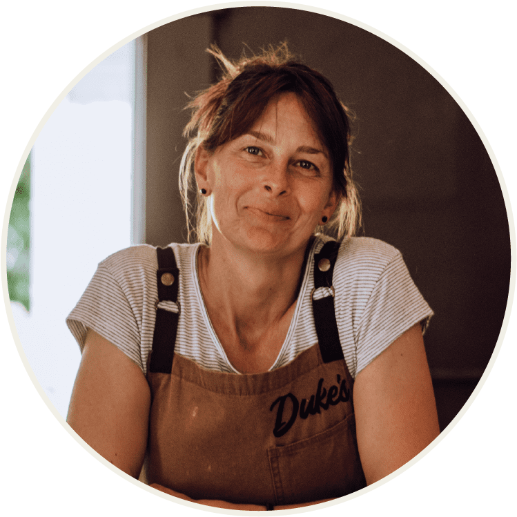 Owner of Duke's Cafe and Bakery leaning on the counter during breakfast hours